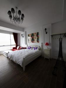 台東市的住宿－伊亞咖啡民宿，卧室配有一张白色大床和吊灯。