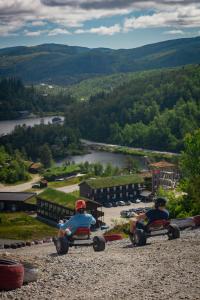 two people riding on toy cars on a hill at Sirdal fjellpark in Tjørhom