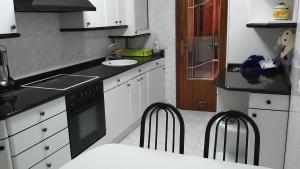 uma cozinha com armários brancos, um lavatório e uma máquina de lavar louça em Piso céntrico y luminoso em Vitoria-Gasteiz