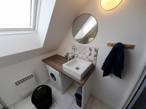 W łazience znajduje się umywalka i lustro. w obiekcie Appartements Lannion proche centre, Côtes de Granit Rose w mieście Lannion