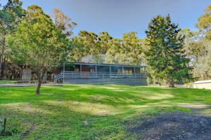 a house on a grassy field with trees at Harberts Lodge Yarra Valley in Launching Place