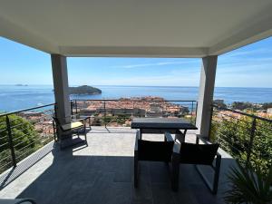 einen Balkon mit einem Tisch, Stühlen und Meerblick in der Unterkunft Apartments Luna in Dubrovnik