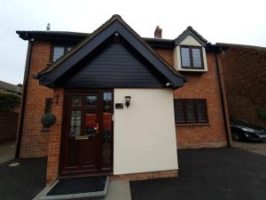 a house with a garage with a door at London Luxury 6 Bedroom Family House Sleeps 12 people Parking for 4 Cars Close to tube. in Chigwell