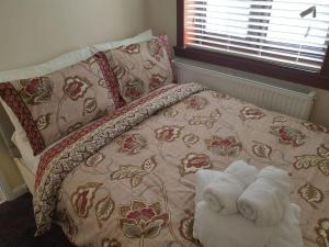 a bedroom with a bed with towels on it at London Luxury 6 Bedroom Family House Sleeps 12 people Parking for 4 Cars Close to tube. in Chigwell