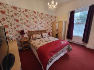 1 dormitorio con cama y papel pintado con motivos florales en Florence Guest House, en Weston-super-Mare