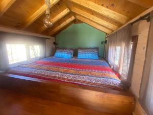 - un lit dans une petite maison dotée de plafonds en bois dans l'établissement Mini Casa Finca Arcoiris Tenerife, à Guía de Isora