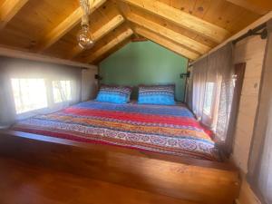 a bed in a tiny house with wooden ceilings at Mini Casa Finca Arcoiris Tenerife in Guía de Isora