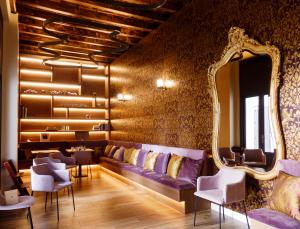 a salon with a purple couch and a mirror at Casa del Cardenal in Córdoba
