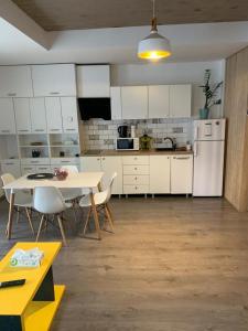 a kitchen with white cabinets and a table and chairs at Teodoroiu nr. 5 in Craiova