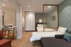 um quarto de hotel com duas camas e uma mesa e cadeiras em The Caravan Apartments em Tessalônica