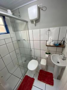 a white bathroom with a toilet and a sink at Canto do Bichinho in Prados