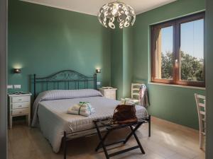 a bedroom with green walls and a bed with a chair at La Volpe e la Stella by Podere Carriero in Montescaglioso