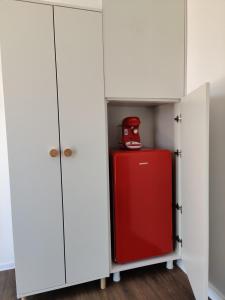 una nevera roja en un armario blanco en Daro tiny house, en Vama Veche