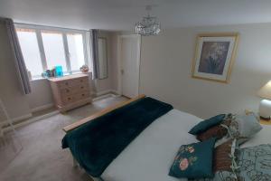 um quarto com uma cama com um cobertor azul em The Den, 2 mins Chelt High Street, John Lewis etc em Cheltenham