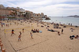 grupa ludzi grających w siatkówkę na plaży w obiekcie Appartement Architecte Catalans- Bord de mer w Marsylii