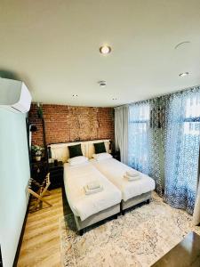 1 dormitorio con cama y pared de ladrillo en BEAUTiQUE HOTEL CITY CENTRE, en Ámsterdam