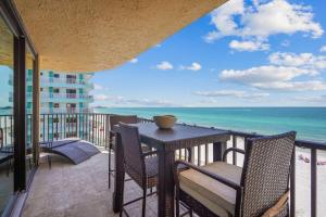 a balcony with a table and chairs and the ocean at Trillium 3A - Premier in St. Pete Beach