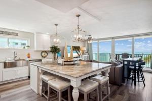 a kitchen with a large island with bar stools at Trillium 3A - Premier in St Pete Beach