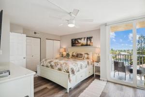 a bedroom with a bed and a balcony at Trillium 3A - Premier in St. Pete Beach