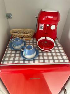 czerwone urządzenie siedzące na lodówce w obiekcie Daro tiny house w mieście Vama Veche