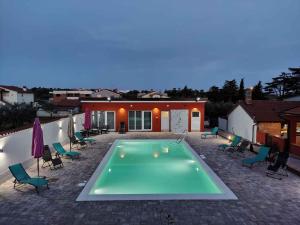 a swimming pool in front of a house at Apartment in Pula/Istrien 11168 in Veli Vrh