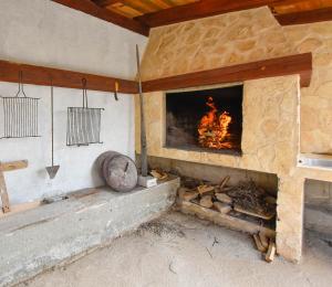 a stone fireplace with a fire in it at House Petra in Žirje