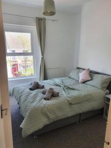 ein Schlafzimmer mit einem Bett mit Kissen und einem Fenster in der Unterkunft Large home Swansea in Swansea