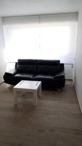 a living room with a black couch and a coffee table at San juan de Alicante 450 € la Semana in San Juan de Alicante