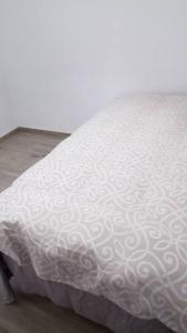 a bed with a white comforter on top of it at San juan de Alicante 450 € la Semana in San Juan de Alicante
