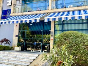 un edificio con toldos azules en la parte delantera en BSA Holiday Park Hotel - All Inclusive, en Golden Sands