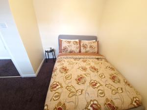 a bedroom with a bed with a bedspread at London Luxury 6 Bedroom Family House Sleeps 12 people Parking for 4 Cars Close to tube. in Chigwell