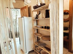 a kitchen with a refrigerator and shelves with baskets at CASA MUNDI in Caraíva