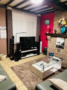 a living room with a flat screen tv and a fireplace at Bien-être-Au-calme et parking gratuit in Seraing