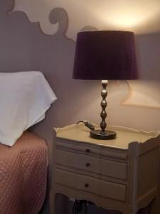 eine Lampe auf einem Nachttisch neben einem Bett in der Unterkunft La Casa Rosa in Pigna