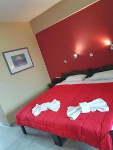 una camera da letto con un letto rosso con un fiocco bianco di CorfuGrace a Sidari
