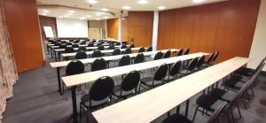 an empty lecture hall with desks and chairs at Heidehotel Soltauer Hof in Soltau