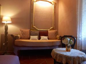 Cette chambre comprend un canapé avec un miroir et une table. dans l'établissement La Casa Rosa, à Pigna