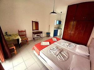 1 dormitorio con 1 cama con toallas en HOLIDAYS STUDIOS & APARTMENTS, en Laganas