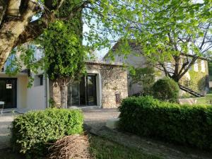 a house with trees and bushes in front of it at La Campagne en Ville in Laragne