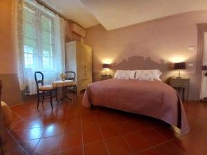 a bedroom with a bed and a table and chairs at La Casa Rosa in Pigna