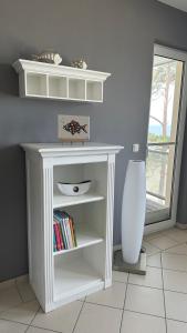 a white book shelf with books on it in a room at Apartment "OCEANVIEW" in Lubmin
