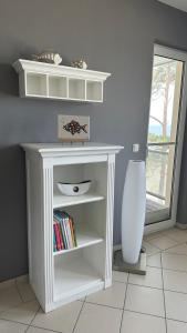 een witte boekenplank met boeken erop in een kamer bij Apartment "OCEANVIEW" in Lubmin