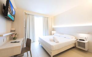 ein Hotelzimmer mit einem Bett und einem TV in der Unterkunft Hotel Carducci in Tortoreto Lido