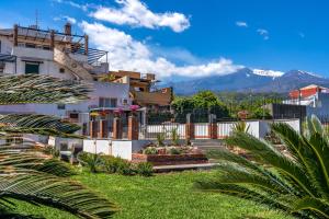 una casa con giardino e montagne sullo sfondo di CASA ZU' SARU a Giarre