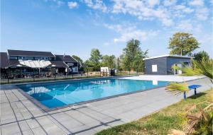 a swimming pool with a house in the background at Vakantiepark De Zeeuwse Parel in Scherpenisse +24 photos