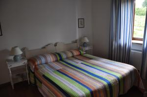 a bedroom with a bed with a colorful striped comforter at Villa Acquafredda in Orvieto