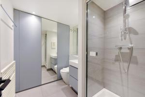 uma casa de banho branca com um chuveiro e um WC. em London Choice Apartments - Covent Garden - Leicester Square em Londres