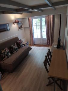 una sala de estar con un sofá y una mesa en Le coin vert, en Deauville 15 fotos más