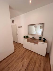 a room with white cabinets and a mirror on the wall at Apartment Södderich 1 in Waake