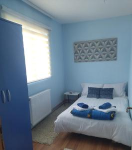 a blue bedroom with a bed with two blue towels on it at Sobe Milica Vrnjacka Banja in Vrnjci